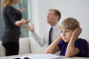 37454648 - sad little boy and family fight in living room